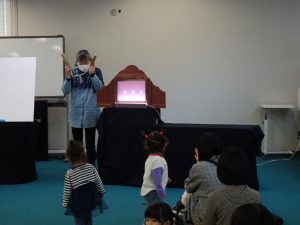 紙芝居開始の拍子木に興味深々の子どもたち。