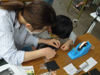 望遠鏡を作る参加者の親子